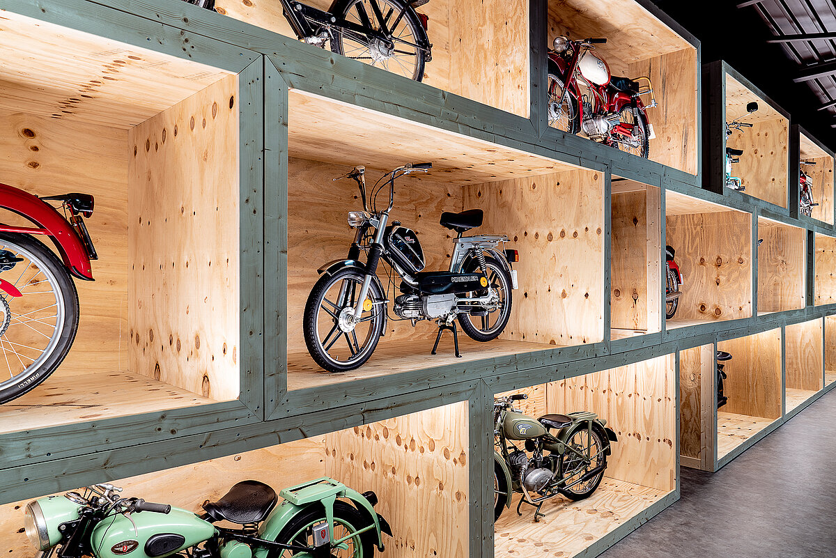 Motorräder stehen wie in einem Regal in der Ausstellungshalle