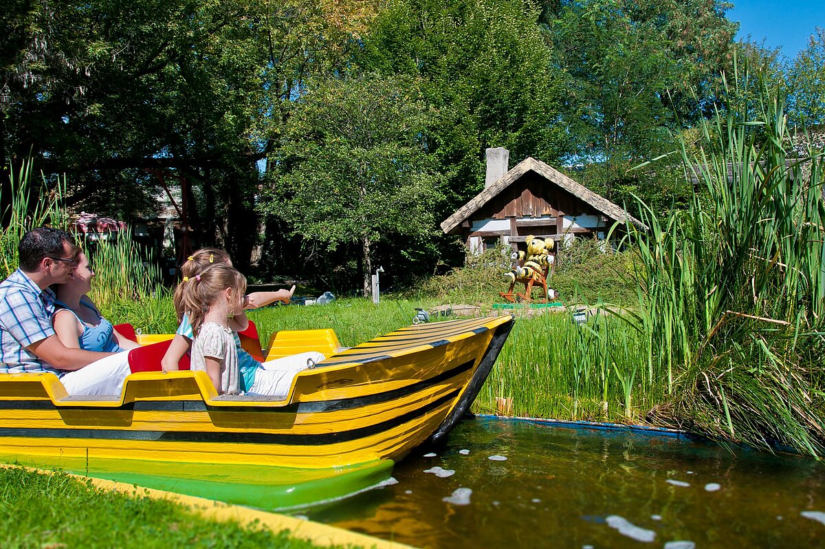 eine Familie sitzt im Boot und macht eine Fahrt durch einen Wasserkanal