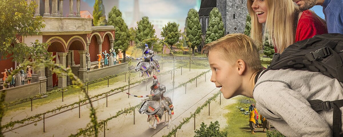 Ein Junge blickt auf eine Miniatur-Version eines Ritterturniers.